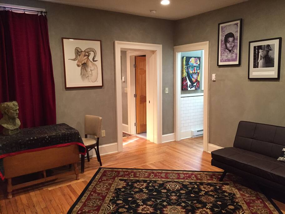 Living room as you walk in. Dining table, couch, view into bedroom and kitchen.