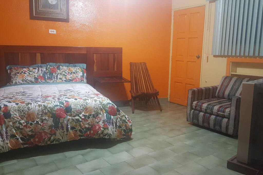 habitacion con espacio para ver television con sofa y silla