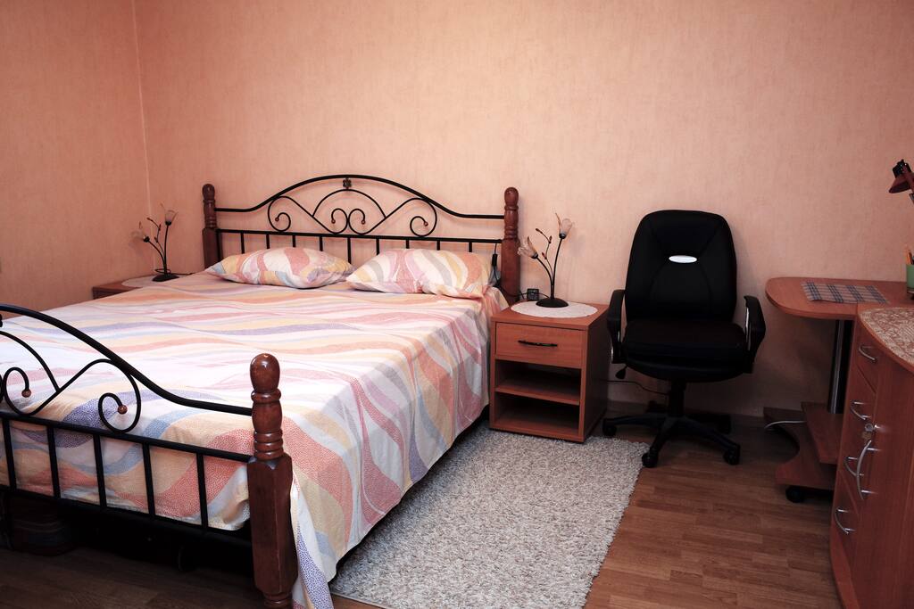 Your bedroom with a queen bed, ceiling fan and desk.