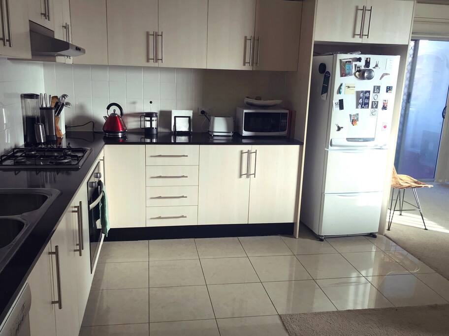 Kitchen equipped with microwave, toaster, blender and other utensils