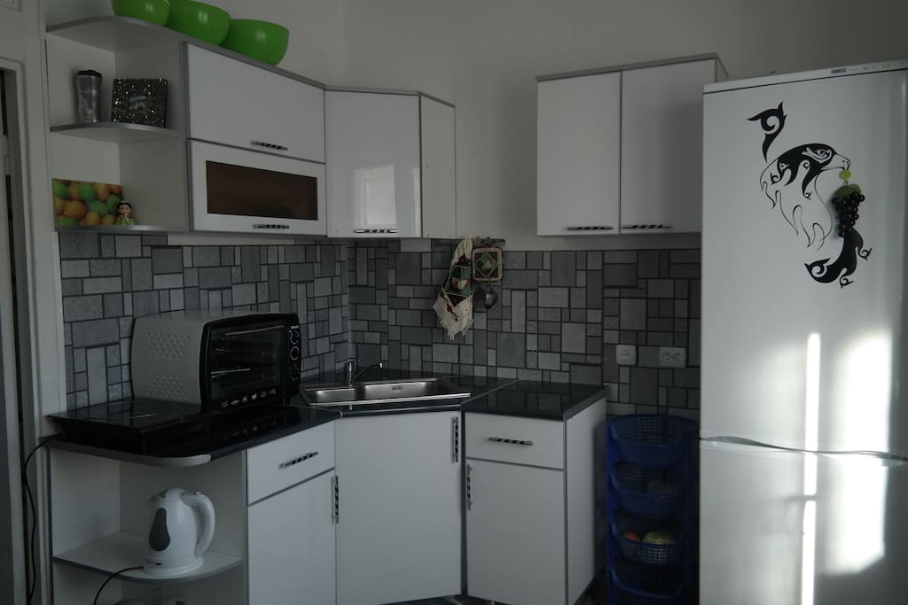 Nice sunny kitchen with a table and 4 taburets.
