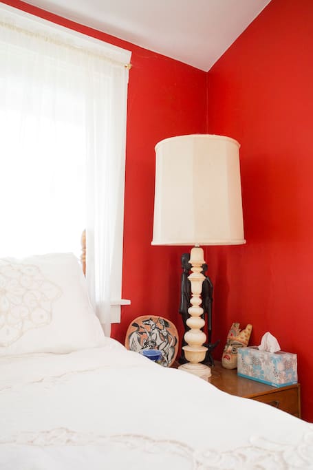 Bedside table and lamp on right side of bed.