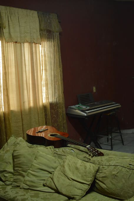 Living room with acoustic guitar and piano
