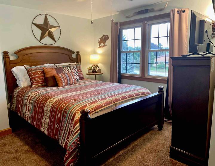 Private upstairs bedroom with a comfortable queen sized bed, 32 inch smart tv, and a snack bar. 
