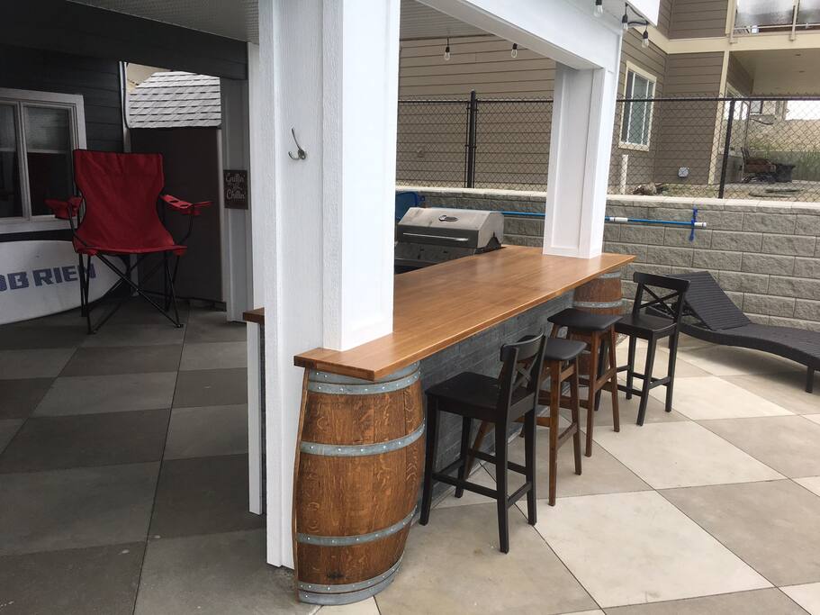 Outdoor kitchen with fridge and bbq.