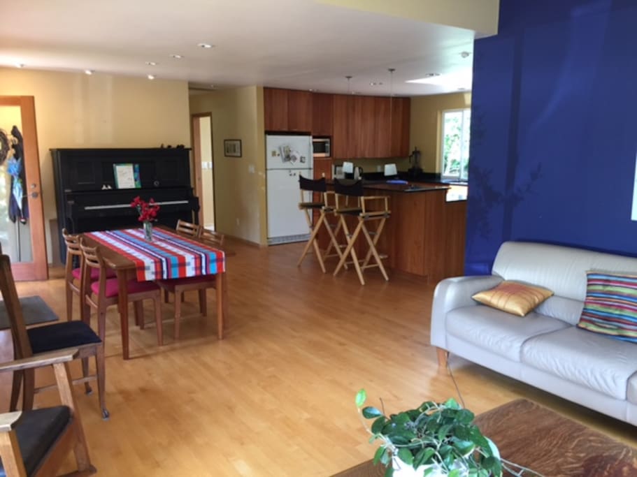 Living room with open view to the entry, dining and kitchen areas. Piano is in ok shape to play!