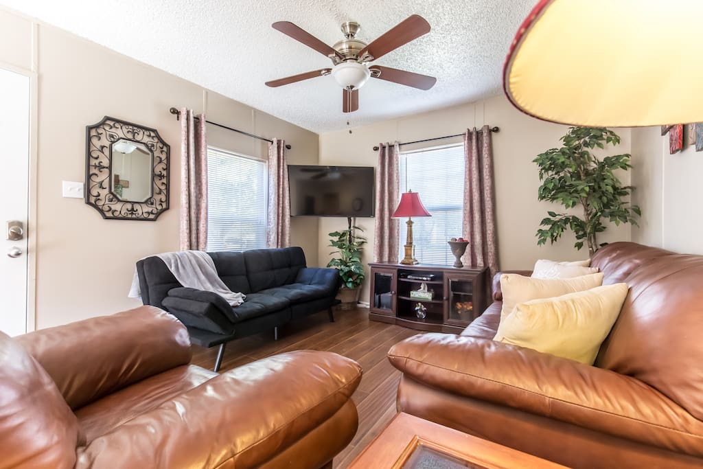 Living Room with a pullout sofa leather couch and chair and ceiling fan.