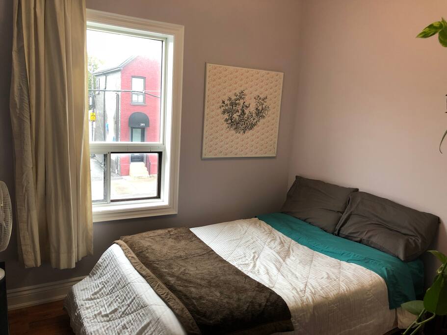 The guest bedroom has a double bed, bright window, closet and dresser.