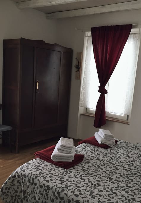 Private bedroom with ancient wood wardrobe and window with mountains view.
Towels included