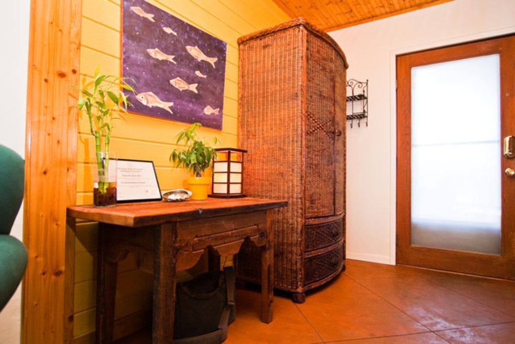 Colorful entry way with wicker storage cabinet.