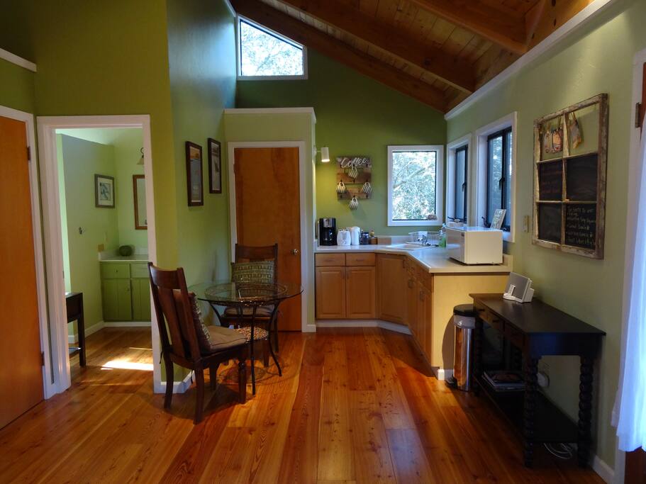 Light living space includes kitchenette, dining for two and mini fridge