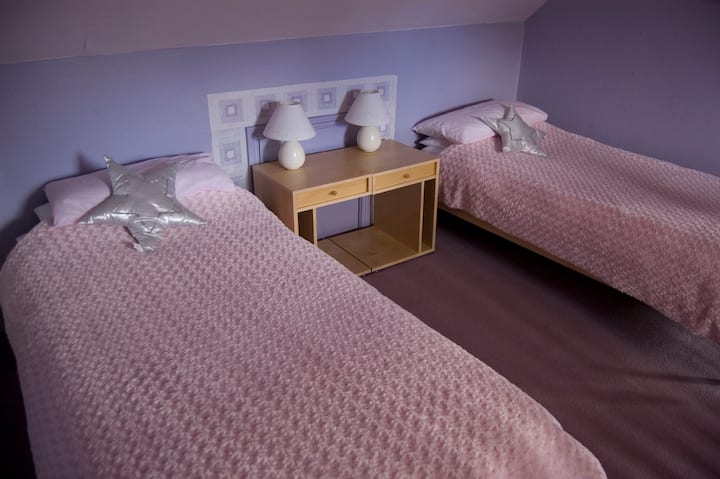 Large second floor bedroom with two beds and futon.