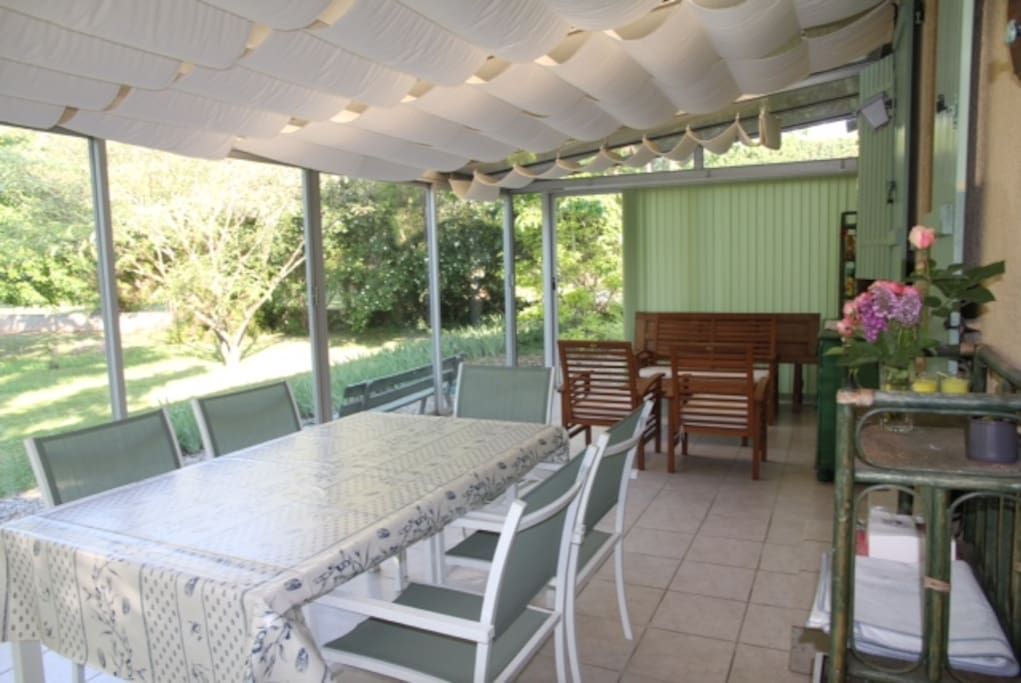 Une véranda sur le jardin de 32 m² avec salon et table pour le repas
