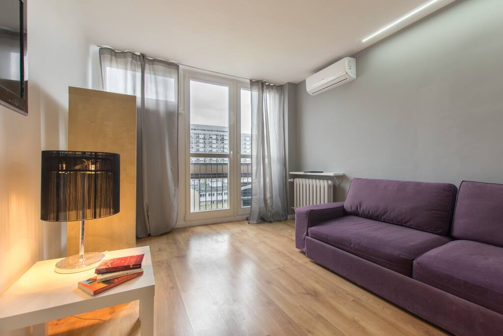 The living room with air-con, 3-person sofa bed, tv, table