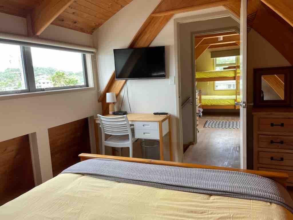 התמונה הזו צולמה מחדר השינה בקומה העליונה עם מיטת קינג סייז. אתם מסתכלים על חדר השינה השני עם מיטות קומותיים. 