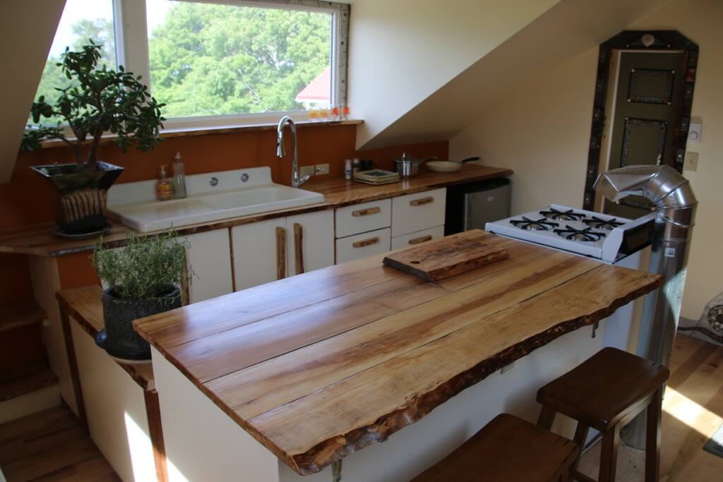 The kitchen island counter features a top made from local maple wood. It's a great place to plug in your devices. Our wifi reaches here no problem.