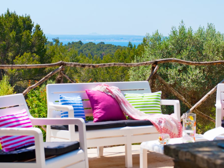 Zona de Sofa exterior "Blanco" con sombra natural y vistas a la Bahía de Alcudia