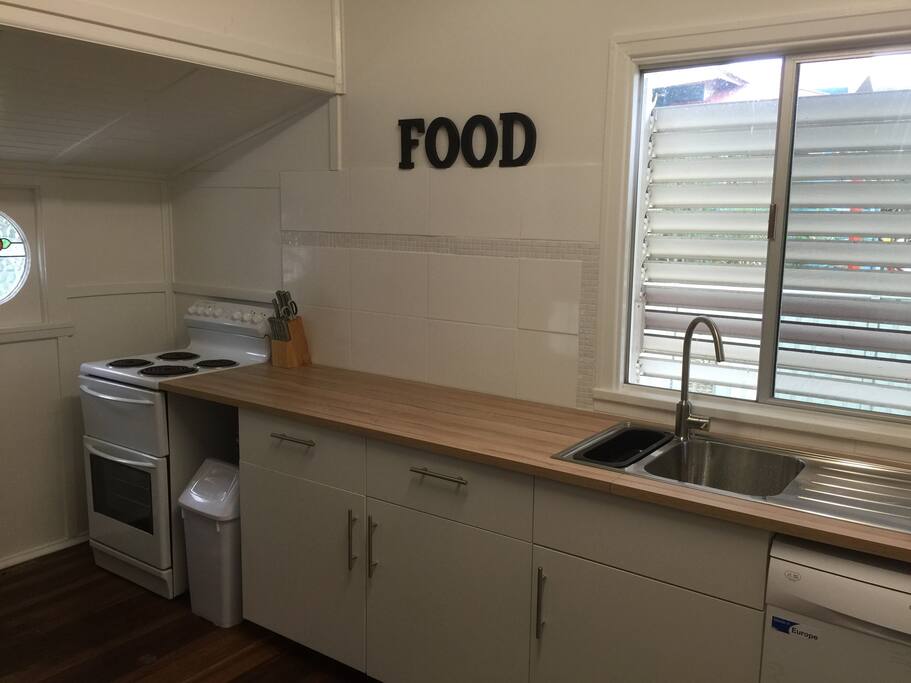 Long kitchen bench for preparation and upright electric stove, oven & grill.