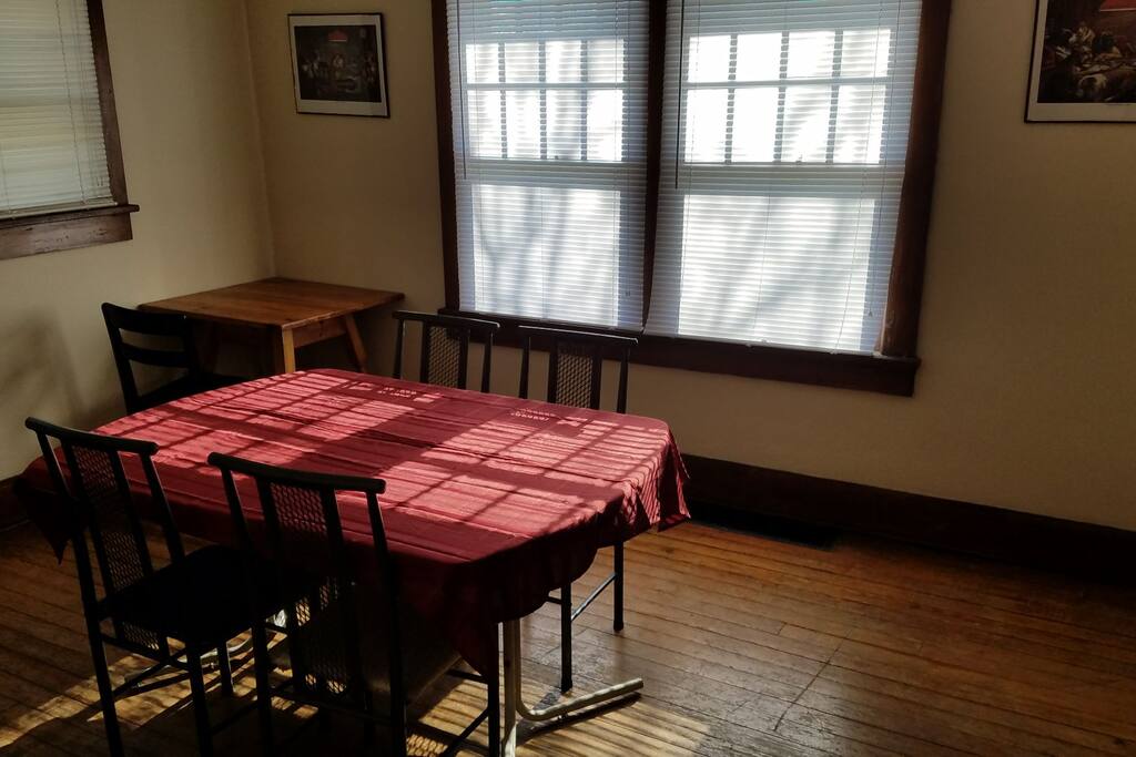 Dining room table with a work desk in the background. Plenty of room to host graduation parties, has ample standing room.