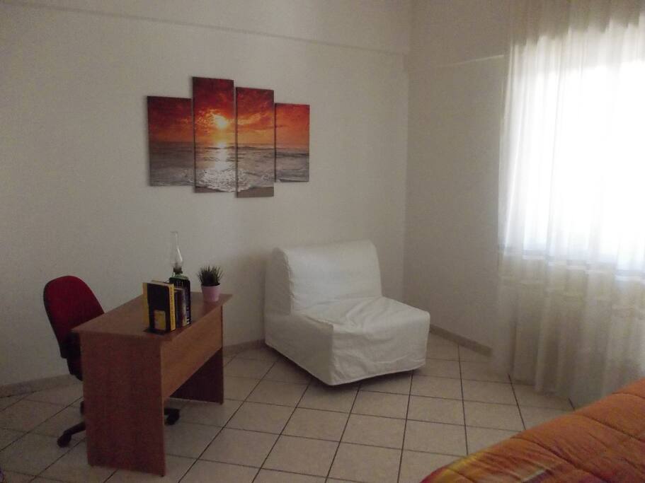 La luminosa seconda camera da letto con scrivania per computer e poltrona letto