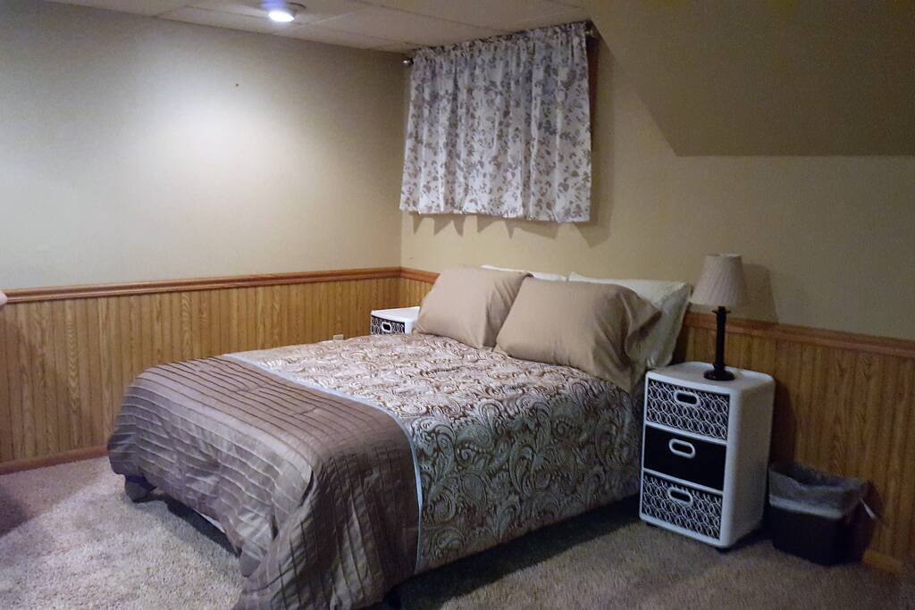 Close up pic of full size bed, sits behind the black sofa.