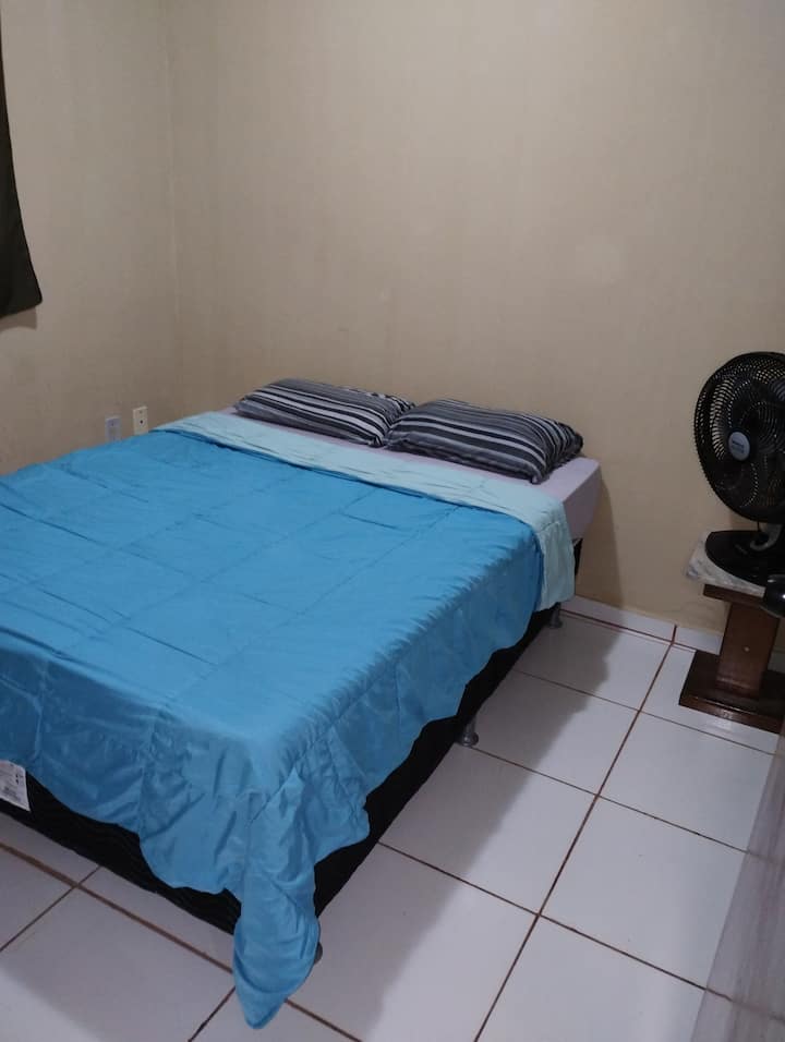 Двойна спалня с вентилатор и спално бельо.