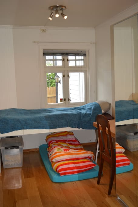 Bed with storage under. Window facing the backyard. Wardrobe with mirror