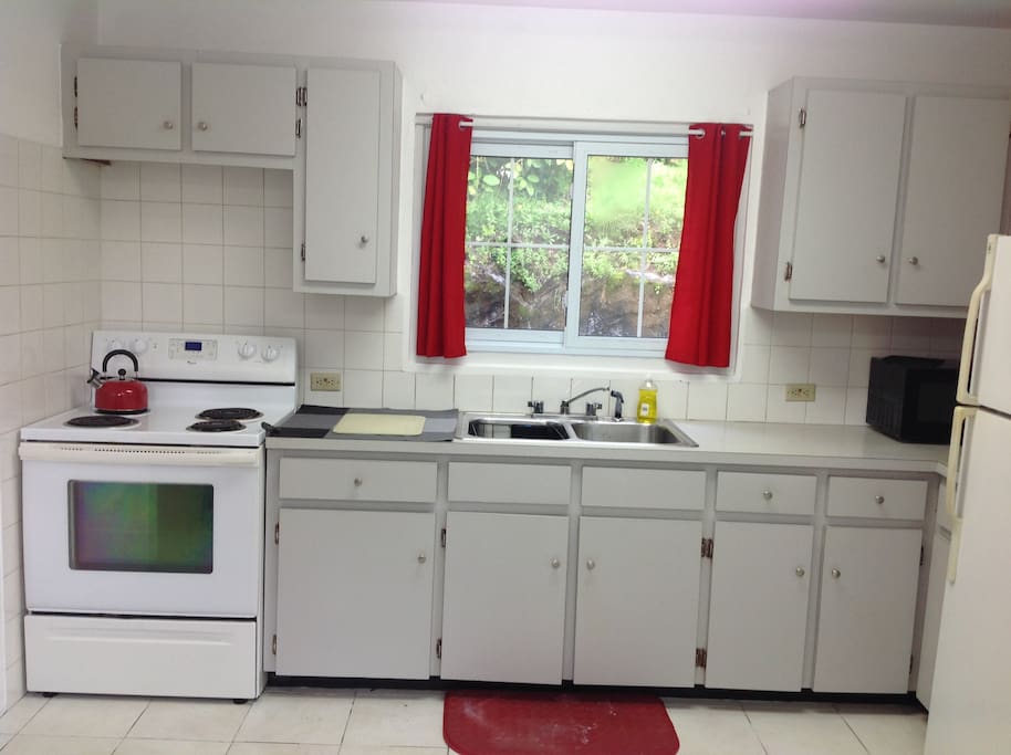 Bright, light and fully equipped kitchen - stove, fridge, microwave, coffeemaker, washer, dryer, and table and chairs.
