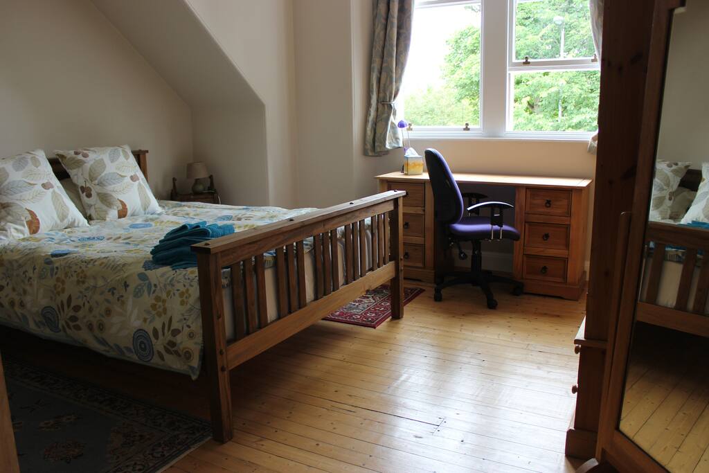 Large double room gets morning sun. Plenty of wardrobe space, and a desk under the window.