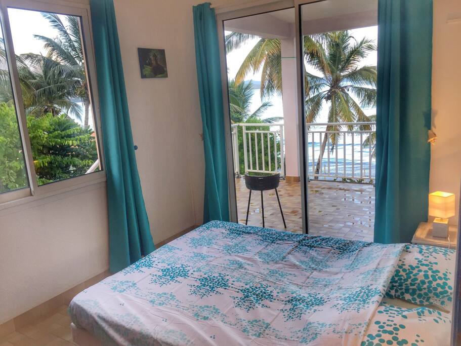 Une première chambre face à la mer et au rocher du Diamant. Double vitrée, climatisation, placard et lit 160, moustiquaire, table et fer à repasser.