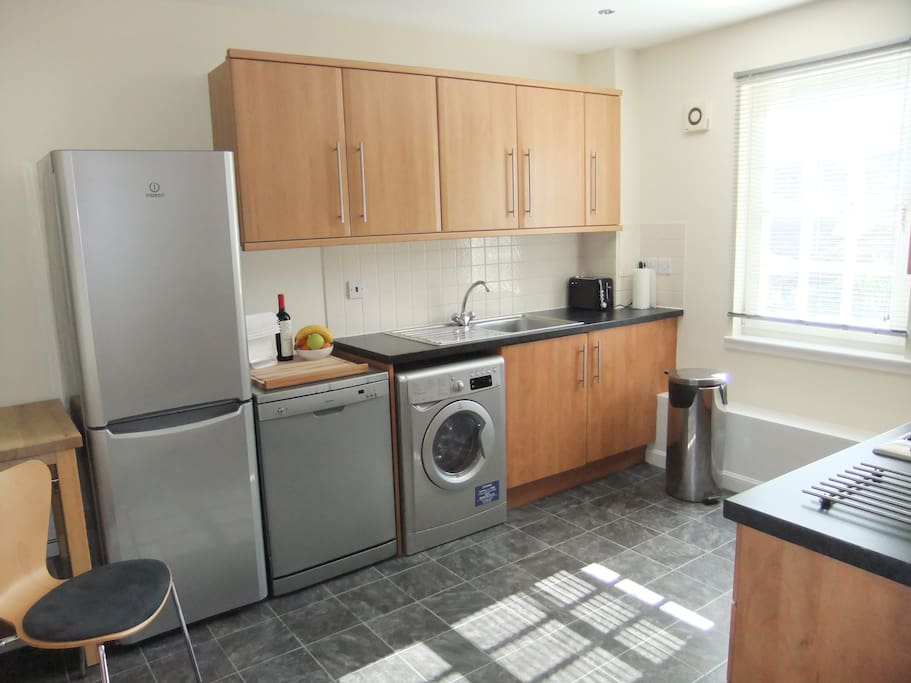 Modern kitchen includes dishwasher, washer and dryer.