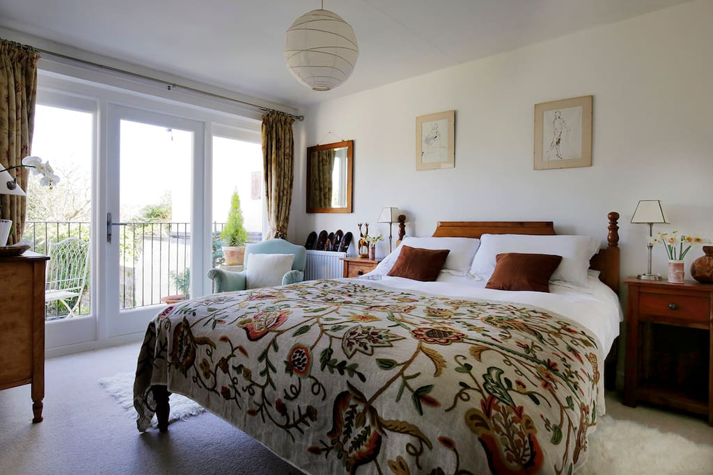 Large light bedroom with balcony and en suite bathroom. View over garden