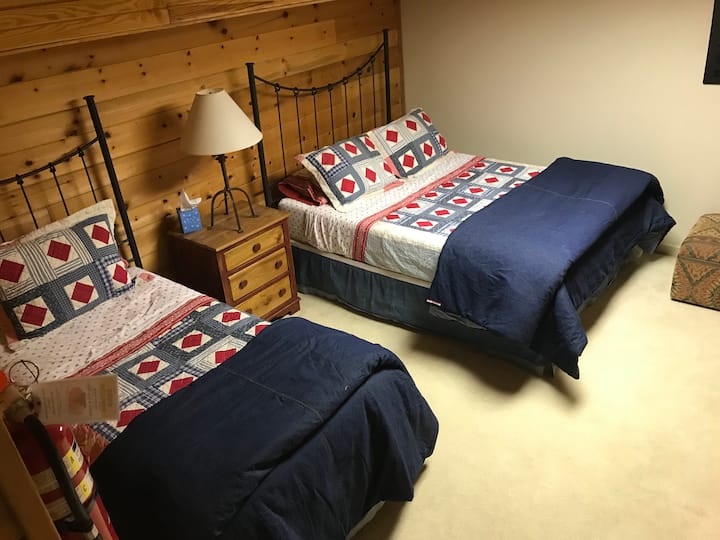 חדר שינה במפלס התחתון עם מיטות זוגיות ומיטות קווין סייז, חדר רחצה 