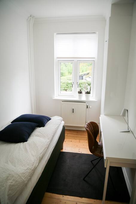 Værelset set fra døren, der går ind til værelset af. Der er udsigt til en skøn ældre park på modsatte side af huset.
Sengen er af rigtig god kvalitet med skøn madres, samt dyne og pude med fyld af andedun. Det vil helt sikkert give dig en skøn søvn.