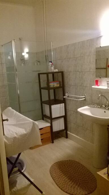 Salle de bain avec douche, table à langer et baignoire pour bébé