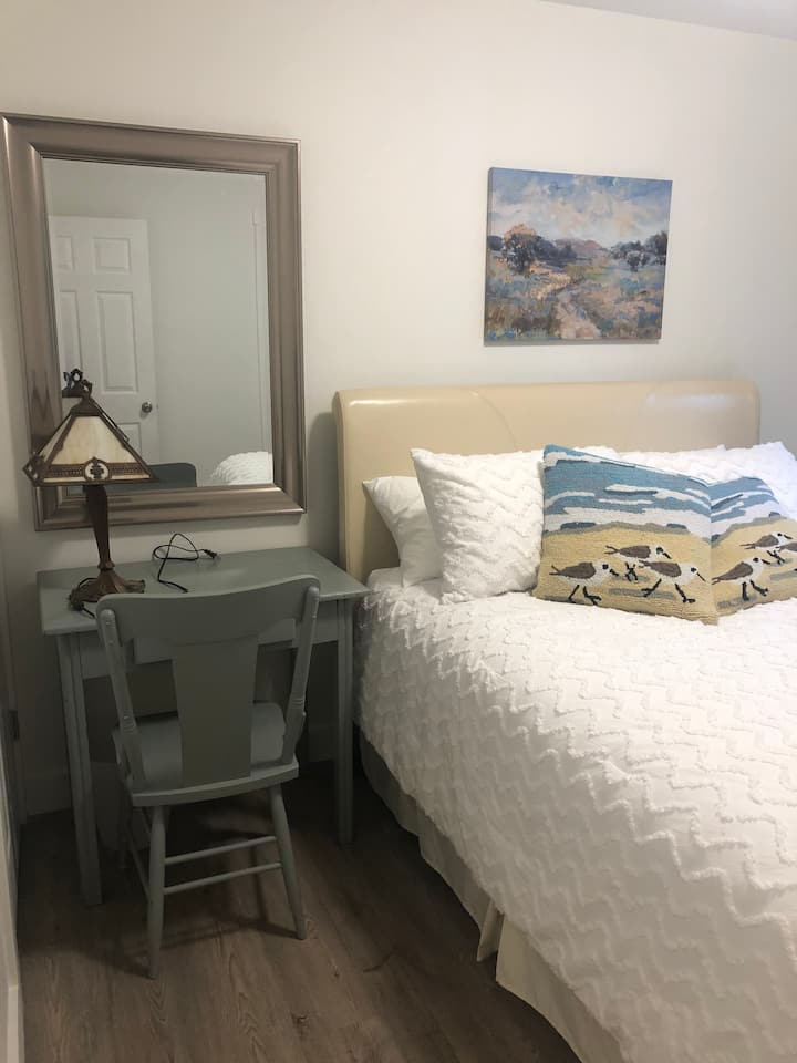 Lovely second queen bedded room. This room has a 7 foot closet organizer. It also boasts a beautiful desk for connecting with friends or working remotely. 