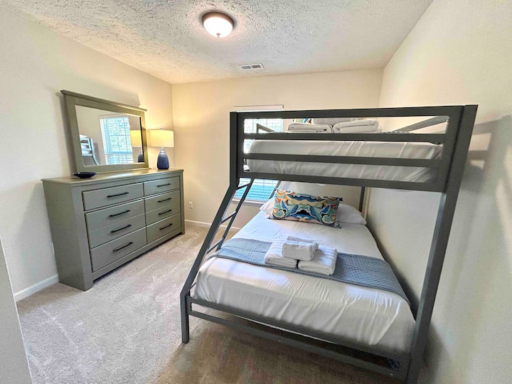 غرفة بطابقين مع سرير كامل في الأسفل وتوأم في الأعلى، والوسائد والفراش محمية بأغطية مضادة للماء.