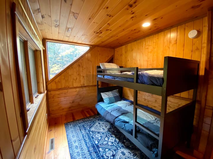 chambre avec lits superposés, salle de bain située au coin juste en bas du couloir
