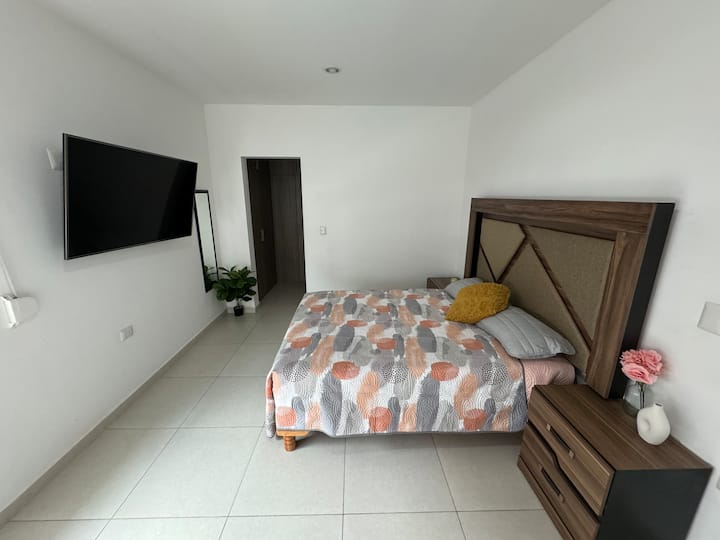 Spacious bedroom with walk-in closet and private bathroom, window overlooking the pool.