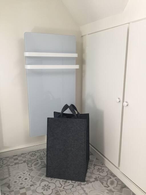 Design glass heated towel rail and grey felt basket.