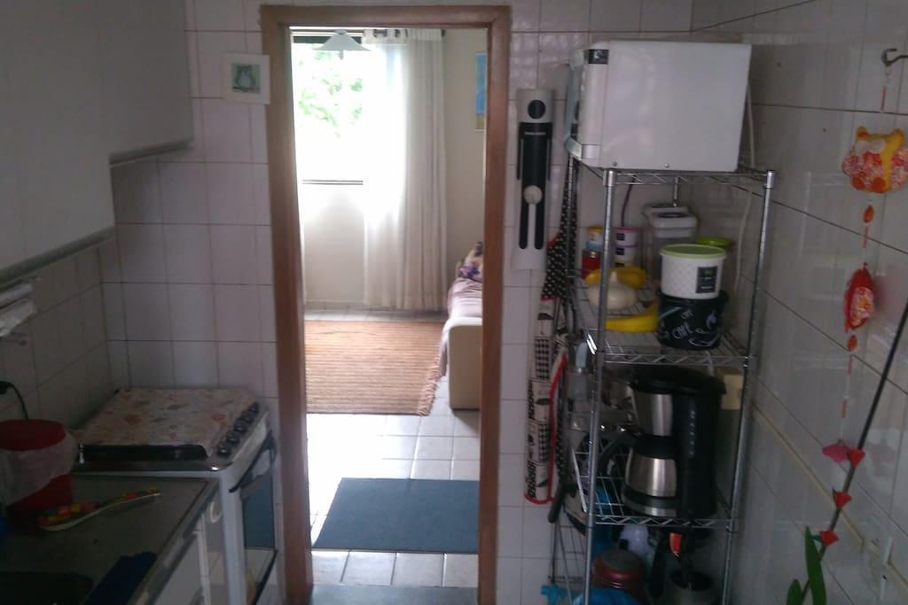Cozinha com fogão, geladeira e máquina de lavar roupa.