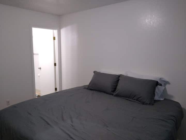 Master bedroom with adjacent bathroom . This bed can be made into 2 twin beds ( 2 twin xl’s & a 4 inch King tempur pedic mattress). 