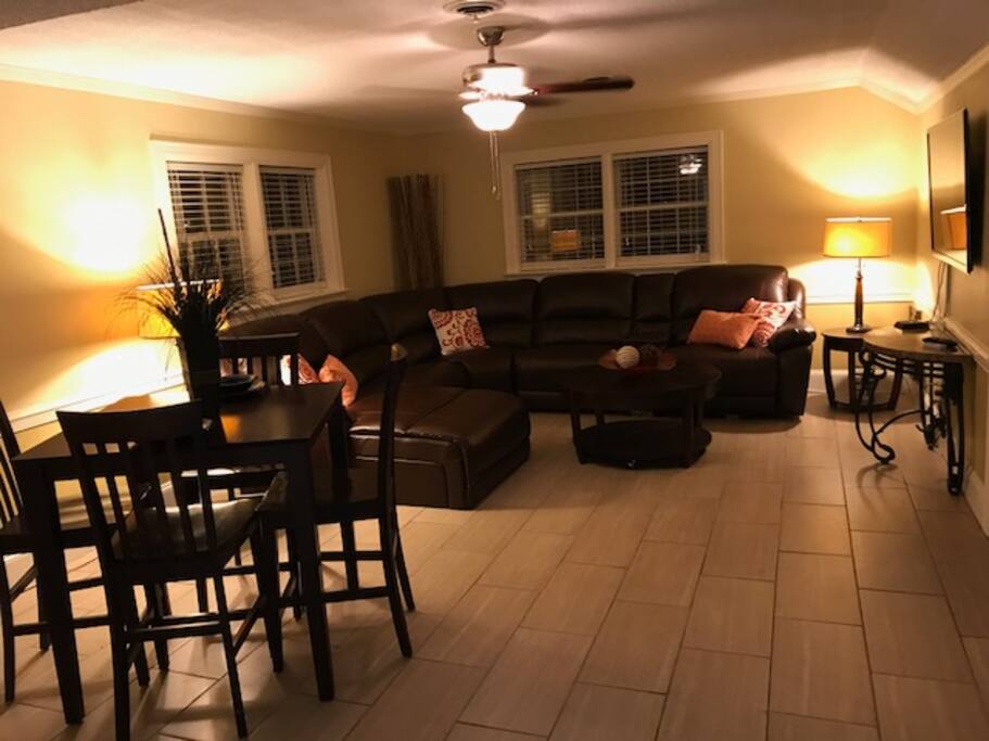 Large living space with leather sectional and breakfast table.