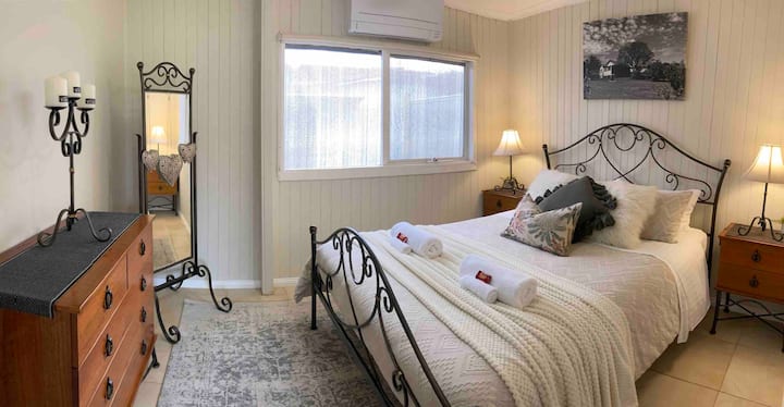 Charming second bedroom with a Queen bed, perfect for relaxing after a day in the Yarra Valley. Features a split system for heating and cooling, stylish décor, ample natural light, and vintage-style furnishings for a cosy, welcoming vibe.