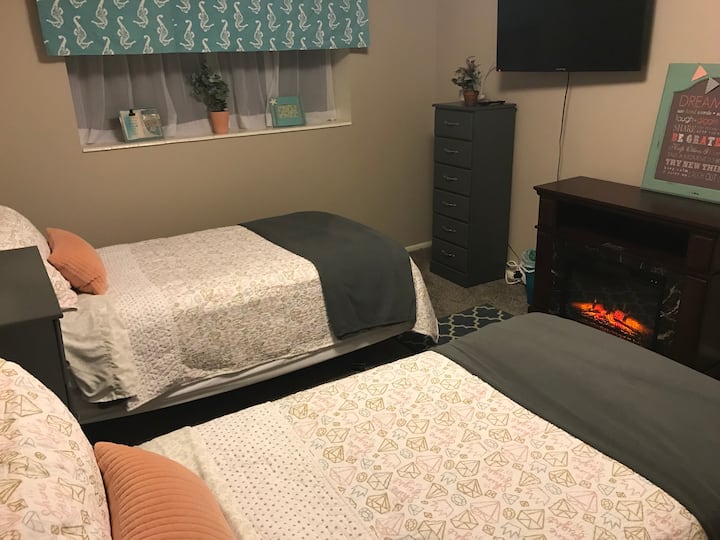 Downstairs bedroom with two XL twin beds, TV, Netfllix, and electric fireplace.