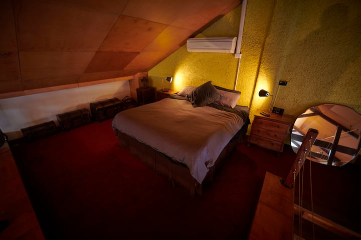 Mezzanine bedroom with king-size bed and air conditioner.