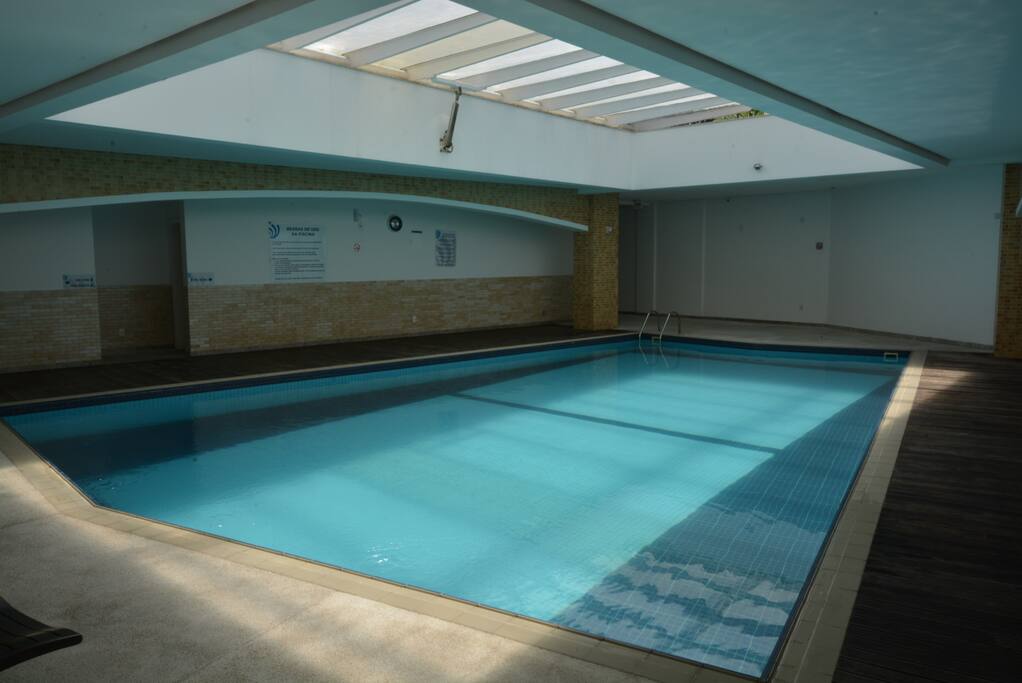 Piscina térmica ampla com sauna no mesmo ambiente.