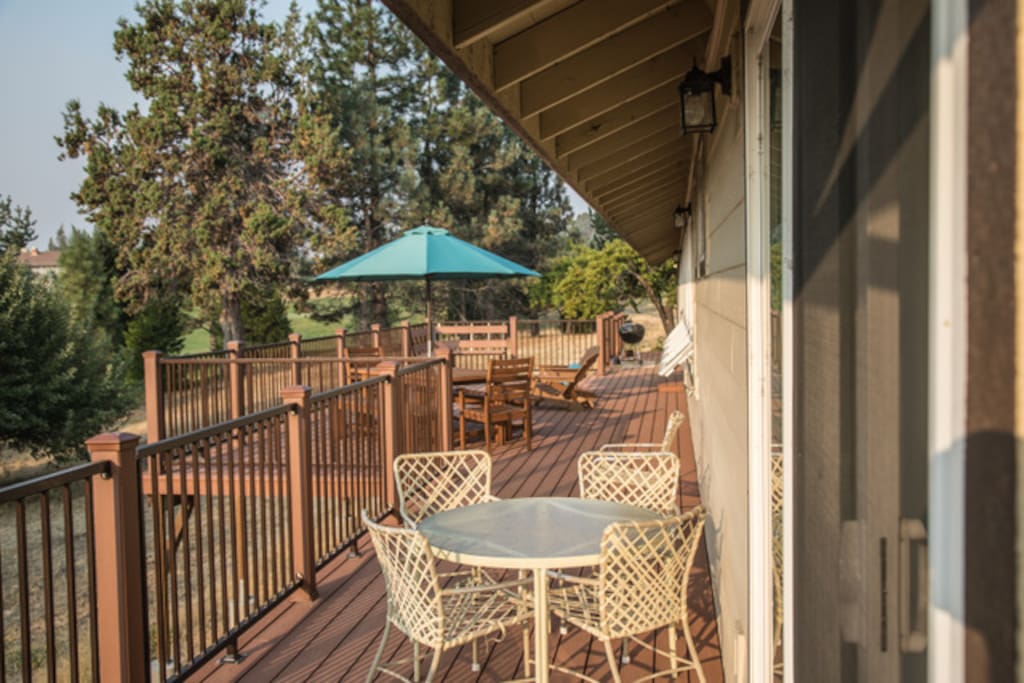Large deck with BBQ, two dining tables and adirondacks