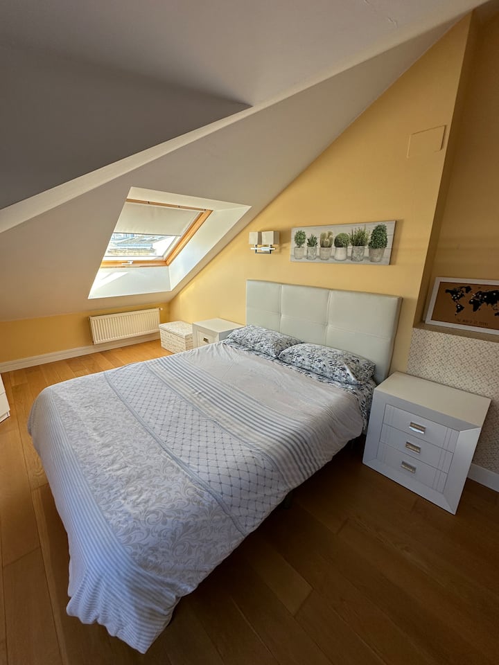Habitación principal en la planta alta con una cama de 150 y un baño dentro de la habitación. Esta habitación abuhardillada cuenta con dos ventanas Velux con vistas directas a Plaza Mayor y Catedral de Lugo.
