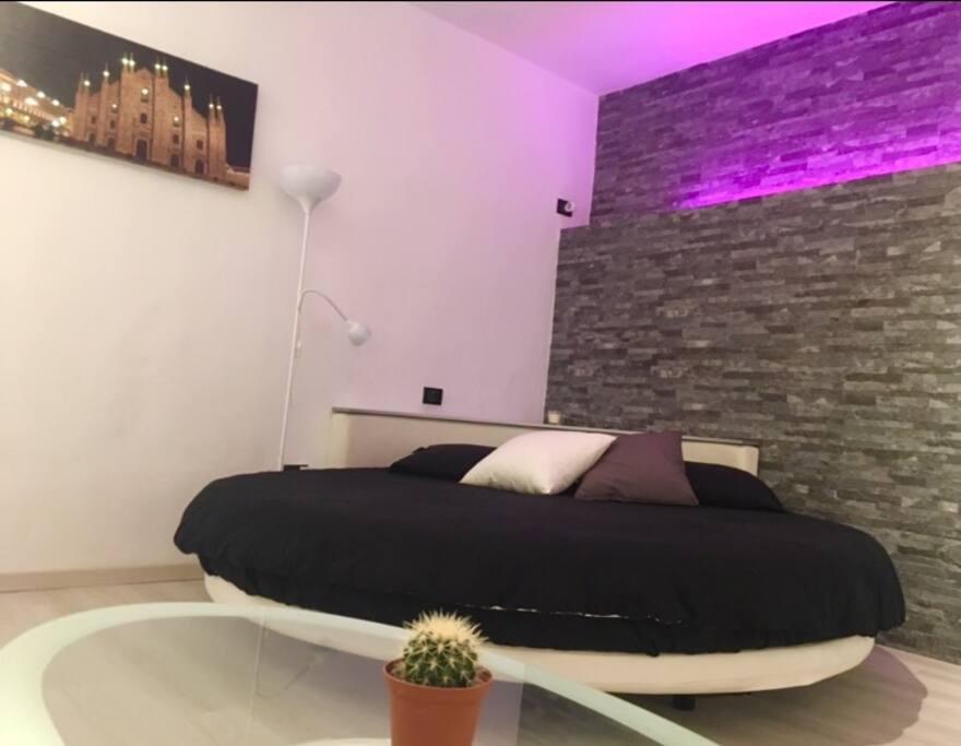 Letto rotondo con parete in pietra